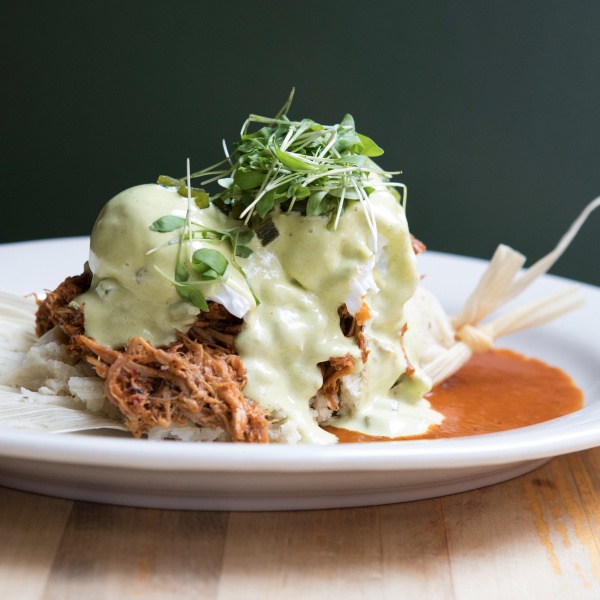 Mexican Eggs Benedict with pulled pork, chipotle hollandaise, and micro greens garnish