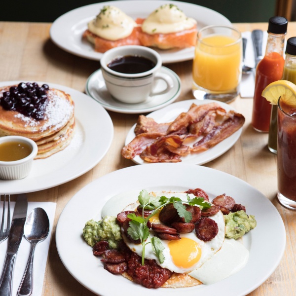 Table for two with Huevos Rancheros, Blueberry Pancakes, Smoked Salmon Benedict, side of bacon, fresh squeezed orange juice, black coffee