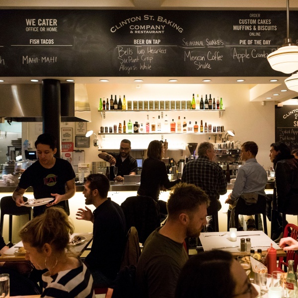 A dinner dining scene with patrons dining in seats and at the bar.